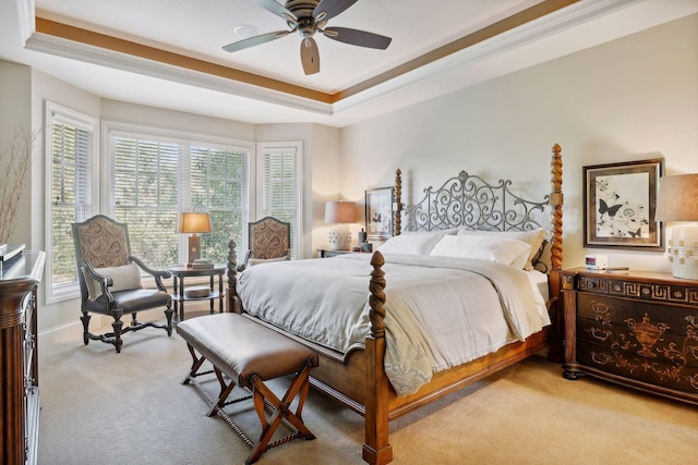 bedroom with ceiling fan, crown molding, light carpet, and a raised ceiling