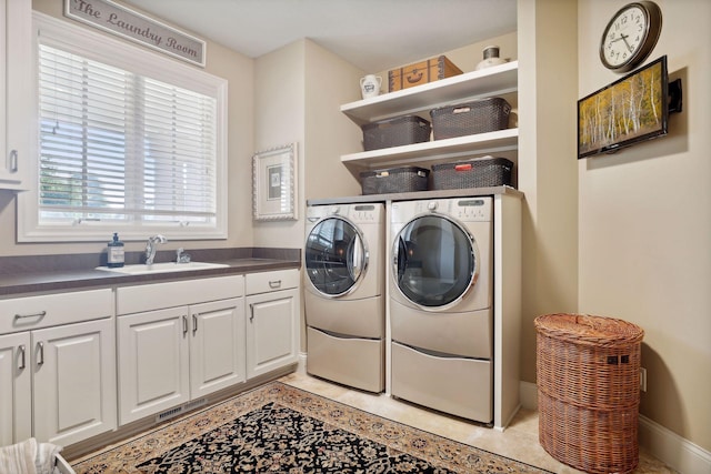 clothes washing area featuring sink, independent washer and dryer, cabinets, and light tile patterned floors