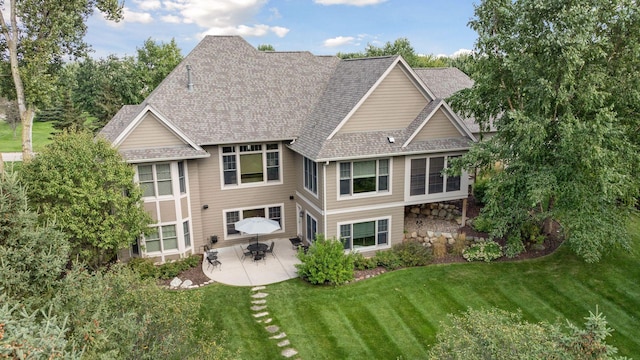 rear view of house featuring a patio area and a lawn