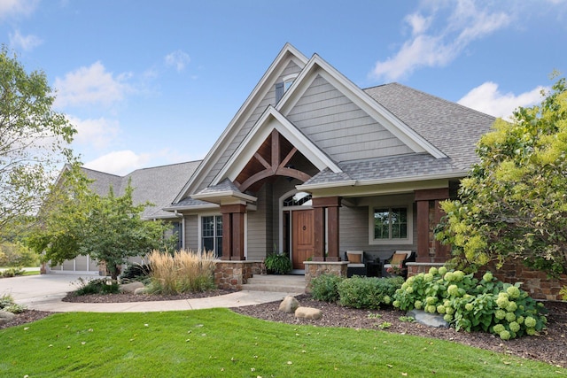 craftsman inspired home featuring a garage and a front lawn