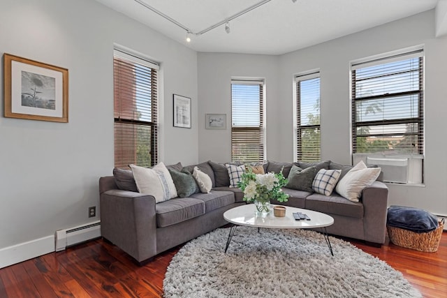 living room featuring baseboard heating, dark hardwood / wood-style flooring, and rail lighting