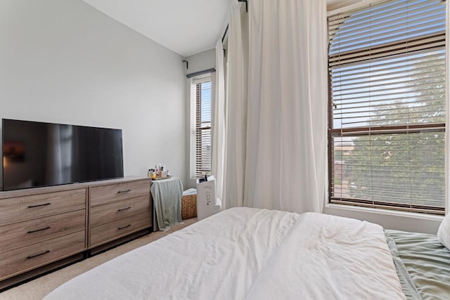 bedroom with lofted ceiling and light colored carpet