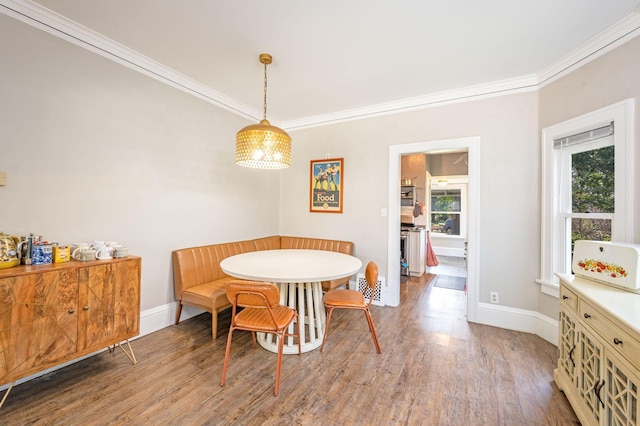 dining area featuring crown molding, hardwood / wood-style floors, and an inviting chandelier