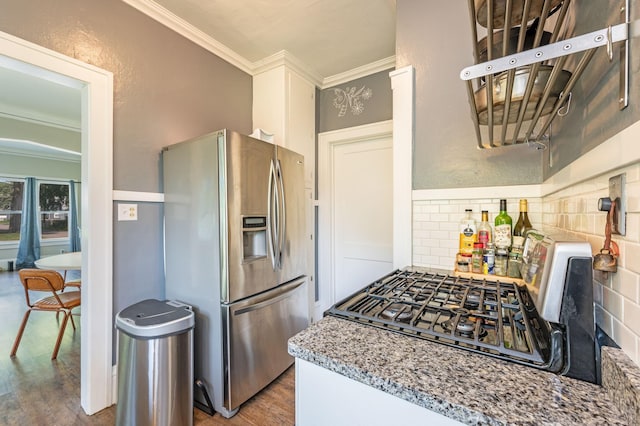 kitchen with dark hardwood / wood-style floors, stainless steel fridge, crown molding, and black gas cooktop