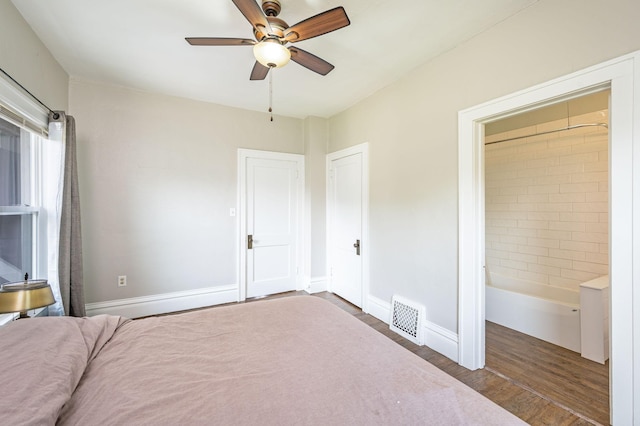 unfurnished bedroom featuring dark hardwood / wood-style floors, ceiling fan, and connected bathroom