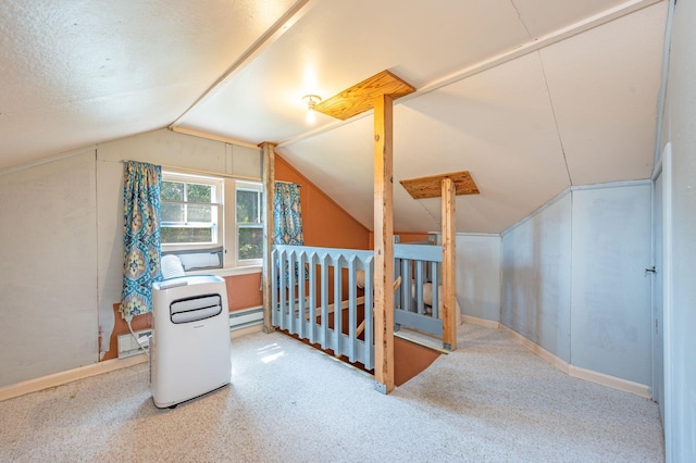 additional living space with baseboard heating, a textured ceiling, carpet floors, and vaulted ceiling