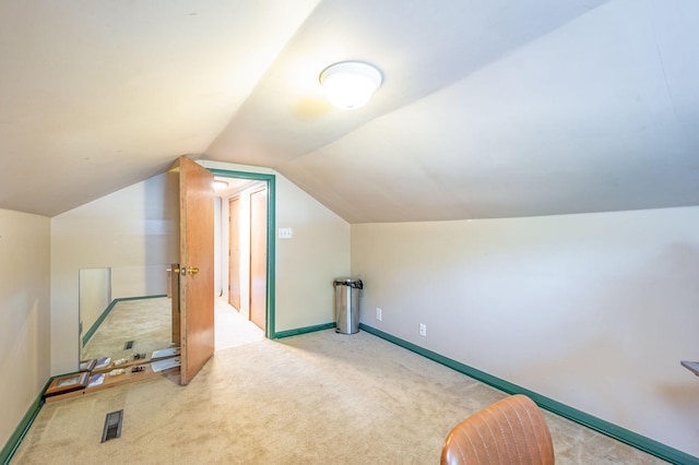 additional living space featuring carpet floors and vaulted ceiling