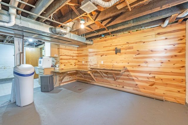 basement featuring a workshop area and wooden walls