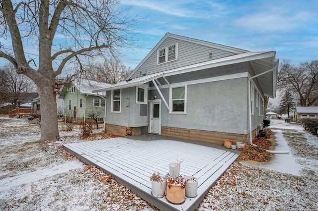 snow covered house featuring a deck