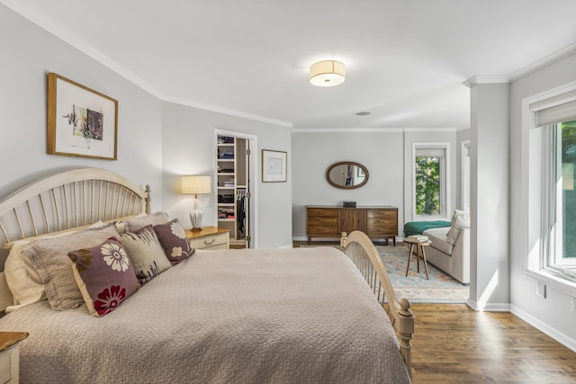 bedroom featuring a spacious closet, dark hardwood / wood-style floors, and crown molding