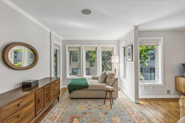 living area with light hardwood / wood-style flooring and crown molding