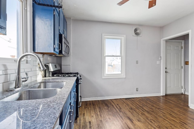 kitchen featuring sink, blue cabinetry, stone counters, and appliances with stainless steel finishes