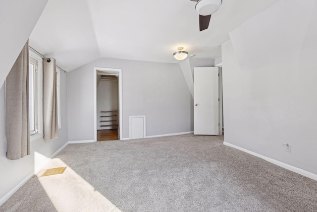 bonus room with lofted ceiling and light colored carpet