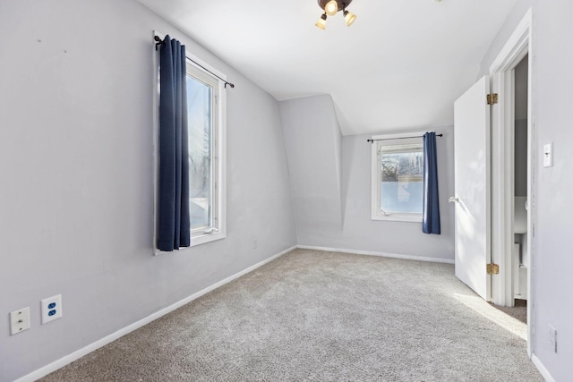 carpeted spare room with lofted ceiling