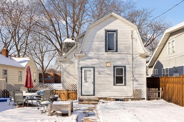 view of snow covered back of property