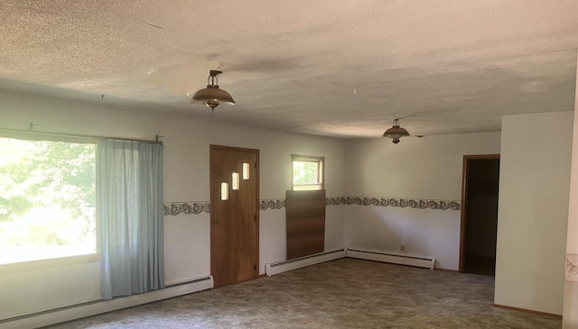 carpeted spare room featuring a textured ceiling and baseboard heating