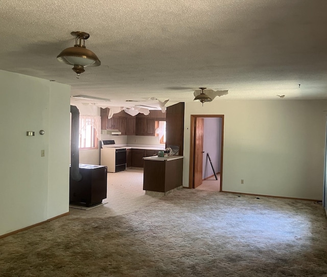 kitchen with dark brown cabinets, white range with electric cooktop, a textured ceiling, and light colored carpet