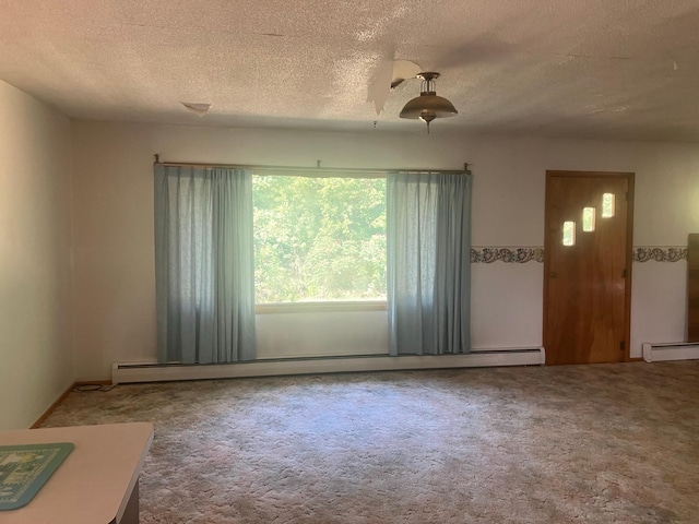 empty room with a textured ceiling, baseboard heating, and carpet