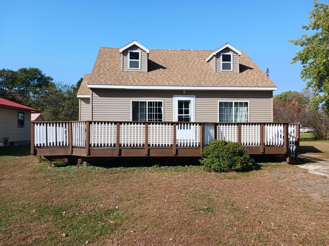 back of house with a deck, a shingled roof, and a yard