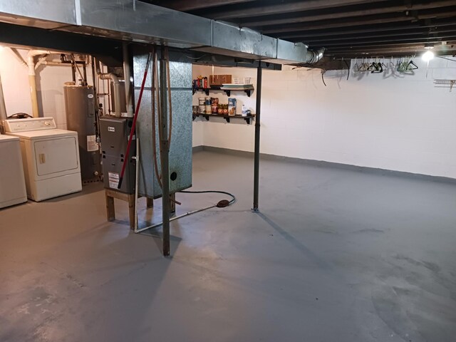 unfinished below grade area featuring washer and dryer and water heater