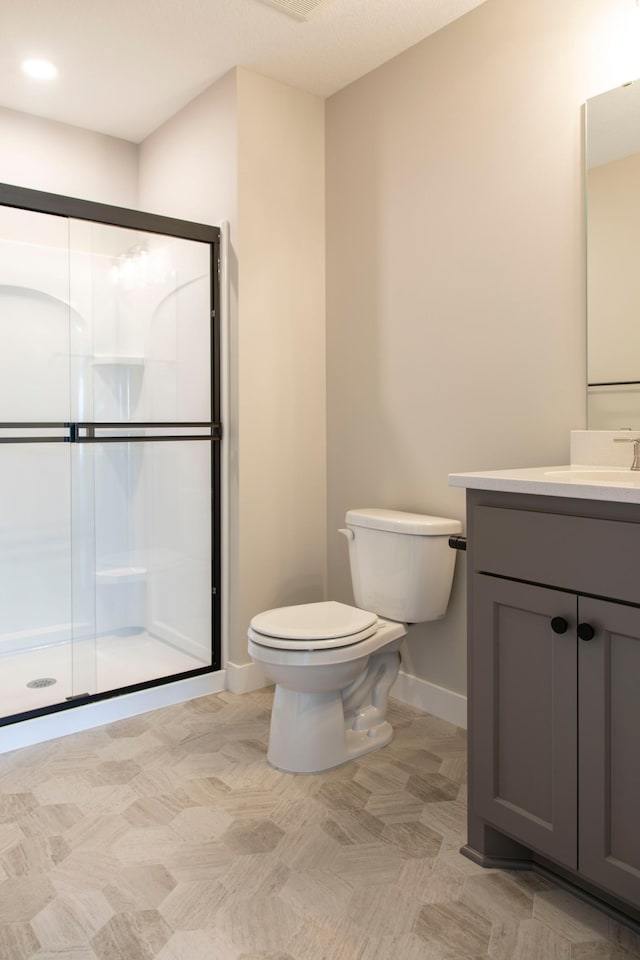 bathroom featuring vanity, toilet, and an enclosed shower