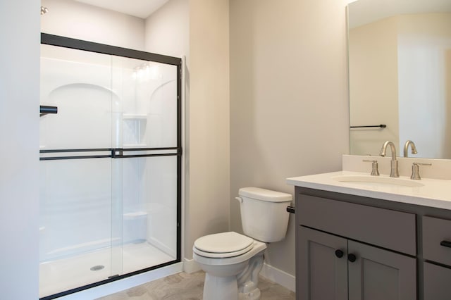 bathroom with vanity, toilet, and a shower with shower door