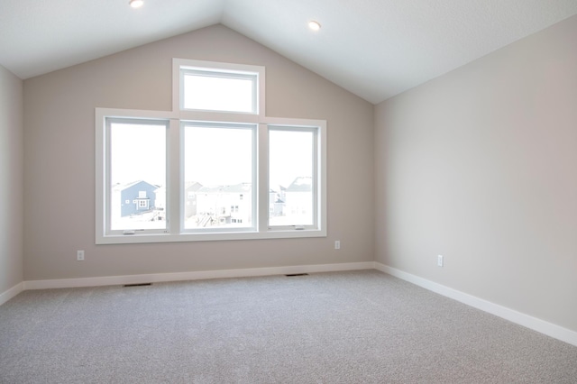 empty room with lofted ceiling and carpet flooring