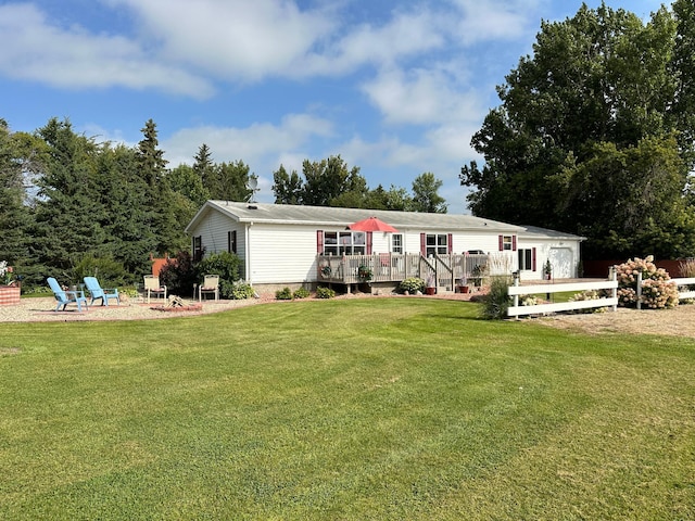 rear view of house with a yard and a wooden deck