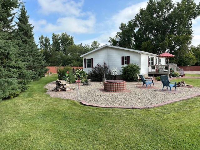 back of house featuring a yard, fence, a patio area, a deck, and a fire pit