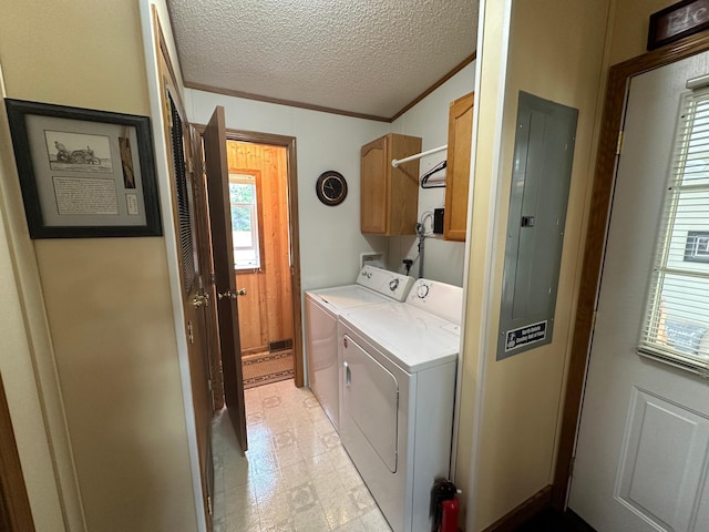 laundry area with washing machine and clothes dryer, a textured ceiling, cabinet space, and electric panel