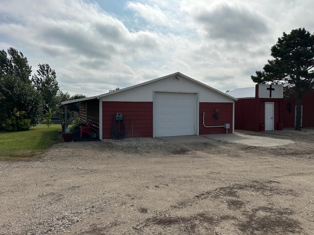 detached garage featuring dirt driveway