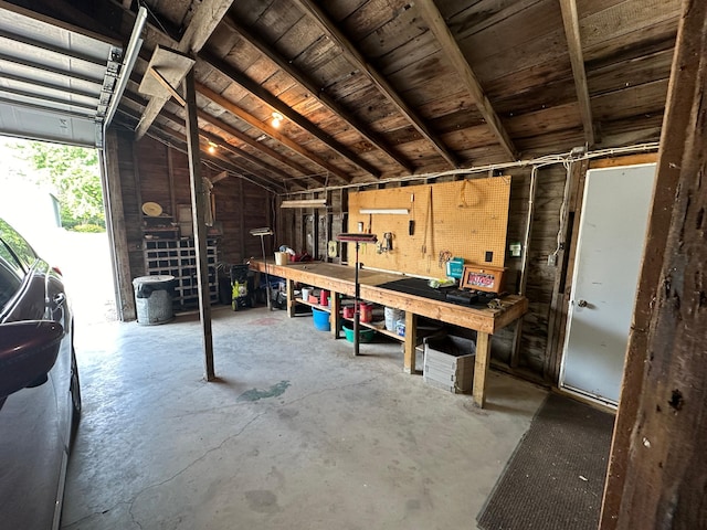 garage featuring a workshop area and wooden walls