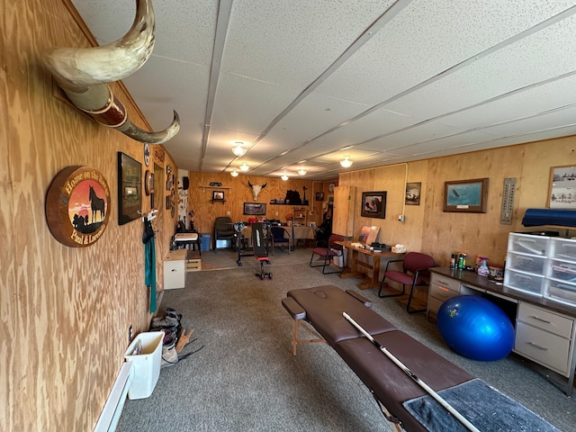 exercise room with wood walls and carpet floors