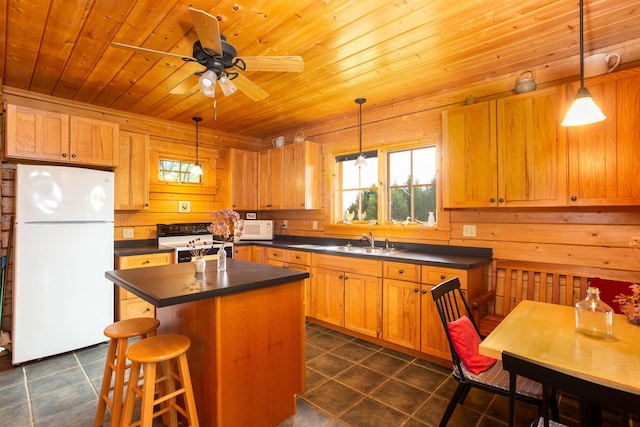 kitchen with dark countertops, wooden ceiling, a sink, and white appliances