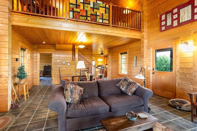 living room with ceiling fan, wood ceiling, and wooden walls