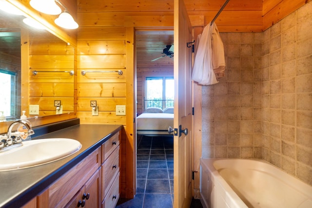 bathroom with tile patterned flooring, vanity, bathtub / shower combination, and wooden walls