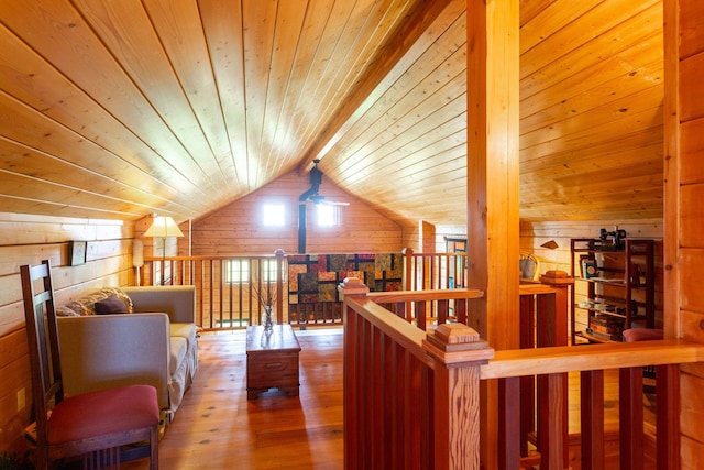 interior space with wood walls, wood ceiling, lofted ceiling with beams, and wood finished floors