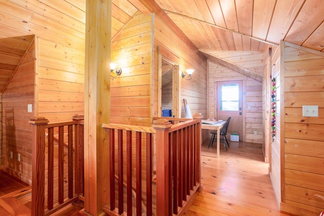 interior space with lofted ceiling, light hardwood / wood-style floors, wood walls, and wood ceiling