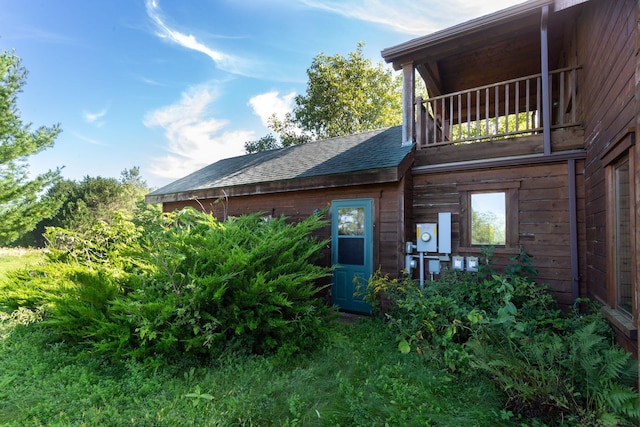 rear view of house featuring roof with shingles