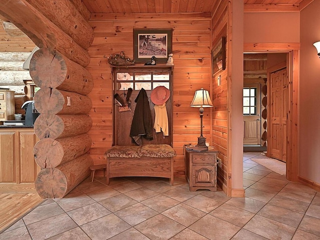 mudroom with rustic walls, light tile patterned floors, and wooden ceiling