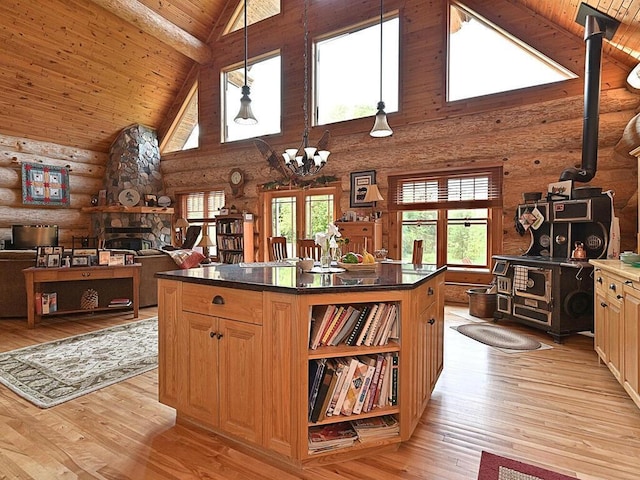 kitchen with rustic walls, high vaulted ceiling, light wood-type flooring, and beam ceiling