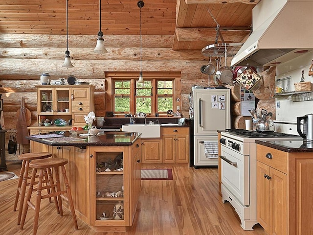 kitchen with light hardwood / wood-style floors, wood ceiling, log walls, and high quality appliances