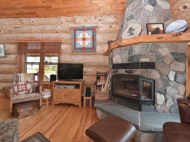 living room with a fireplace, a wood stove, rustic walls, wooden ceiling, and light hardwood / wood-style floors