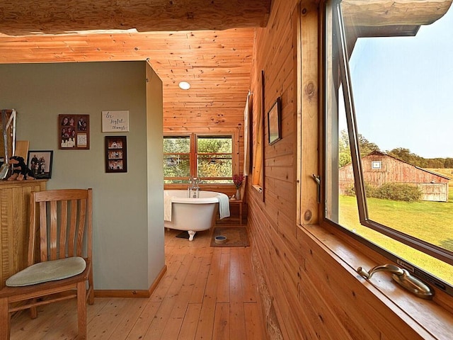 hallway with light wood-type flooring and wood walls