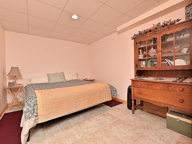 bedroom featuring tile patterned flooring and a drop ceiling