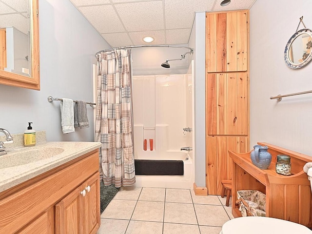 full bathroom featuring toilet, a drop ceiling, tile patterned flooring, vanity, and shower / tub combo with curtain