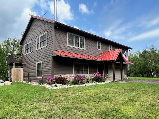 view of front facade featuring metal roof, aphalt driveway, and a front lawn