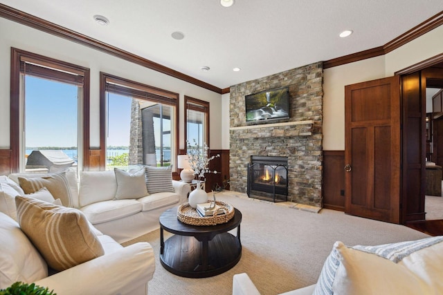 living room with crown molding, wainscoting, a fireplace, carpet floors, and recessed lighting