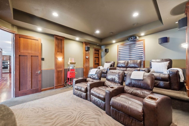 cinema room with a raised ceiling, wainscoting, recessed lighting, and carpet floors