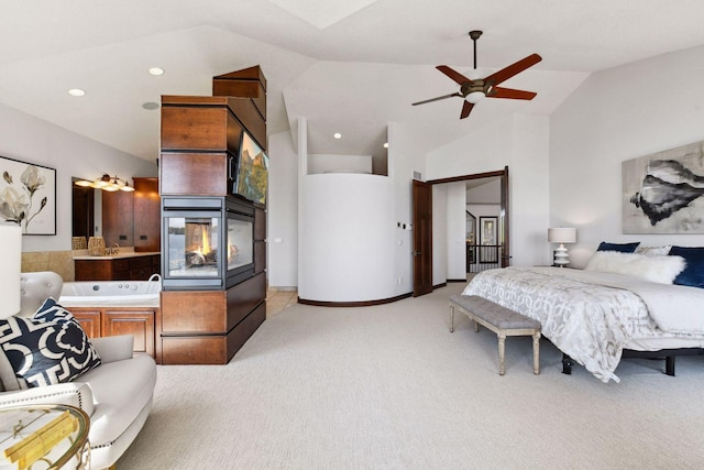 bedroom with light colored carpet, high vaulted ceiling, and ensuite bathroom